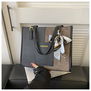 Detail of black and brown tote bag with decorative silk scarf and FASHION lettering
