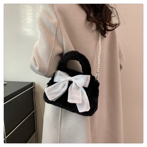 Modèle portant un sac en peluche noir avec grand nœud blanc et bandoulière en perles