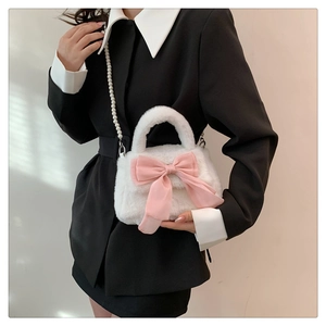 Détail du sac à bandoulière en peluche blanche avec nœud rose et bandoulière en perles