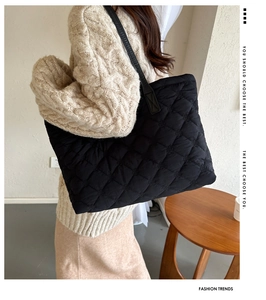 Detail of black quilted tote bag showing rhombus stitching and textured cotton fabric