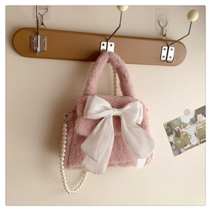 Sac à main en peluche rose avec un grand nœud blanc et une bandoulière en perles chics