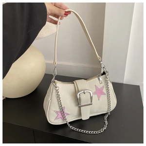 Détail du sac sous le bras en toile avec broderie d'étoile rose et chaîne argentée