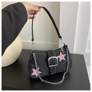 Détail du sac en toile noire avec étoiles roses et grosse chaîne métallique tendance