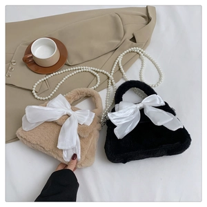 Détail du sac à main en peluche avec nœud en satin blanc et chaîne en perles élégante