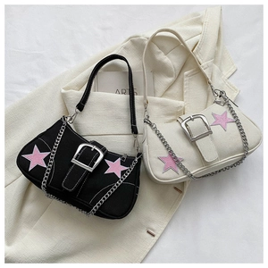 Detail of canvas shoulder bags with star patches, metal buckles and silver chain straps