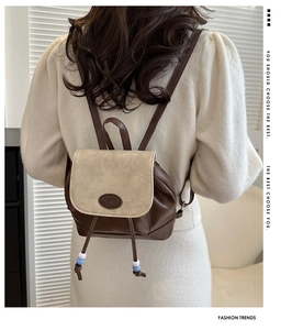Close-up of a retro contrast leather backpack with adjustable straps and beaded drawstring detail