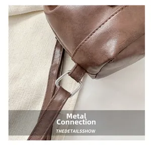 Macro detail of the metal buckle and retro brown faux leather strap on a shoulder bag