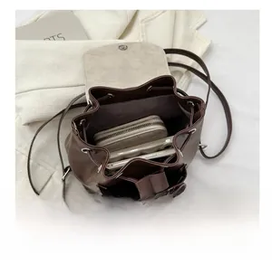 Spacious interior of brown leather drawstring backpack showing capacity for phone and wallet