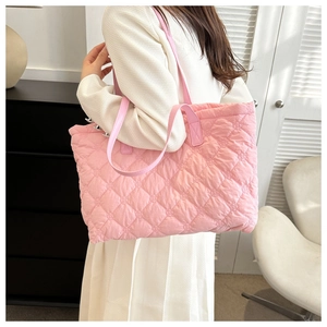 Pink quilted cotton tote bag with shoulder straps worn by model in minimalist setting