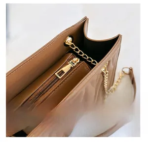 Detail view of smooth metal zipper and internal compartment on brown quilted bag