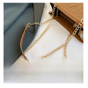 Detail presentation of high-quality gold chain and leather shoulder strap on a quilted bag