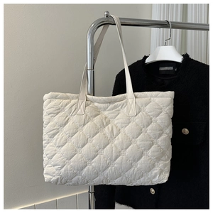 Detail of white quilted tote bag with diamond stitching on lightweight cotton fabric