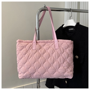 Detail of pink quilted tote bag with diamond stitching and double shoulder straps