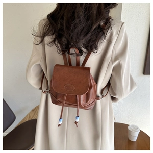 Detail of vintage brown leather mini backpack with fashion embossing and drawstrings