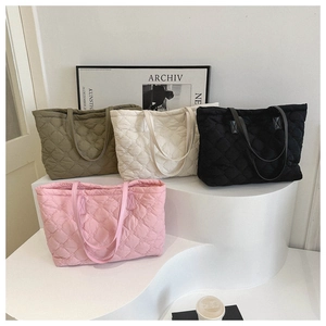 Diamond quilted tote bags in pink, green, white, and black on minimalist white display stands