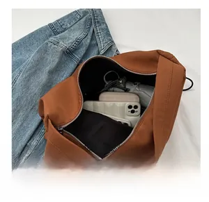 Interior view showing large capacity of the caramel nylon shoulder bag with essentials