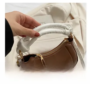 Détail de la poignée nouée blanche et du sac selle croissant en cuir marron