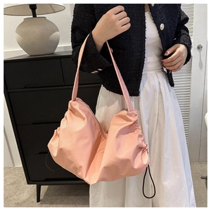 Detail of pink nylon tote bag with adjustable side drawstrings and top metal zipper