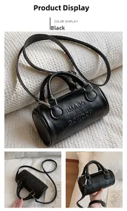 Detail view of black Boston barrel bag showing handle and brand embossed texture