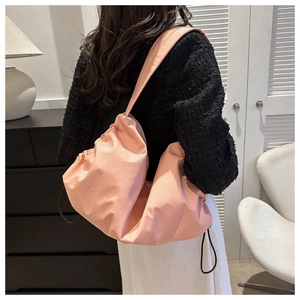 Detailed shot of pink pleated gym bag showing soft texture and drawstring side detail