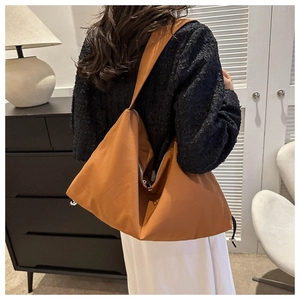 Brown large capacity tote bag side view showing shoulder strap and zipper detail