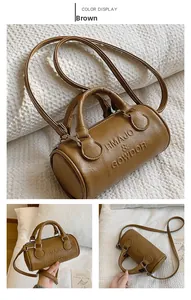 Detailed view of brown Boston bag showing pebbled leather texture and embossed logo