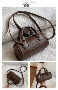 Detail of coffee brown cylinder bag featuring lychee grain leather and brand embossing