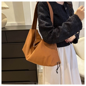 Detail of camel nylon hobo bag showing adjustable drawstring and soft pleated texture