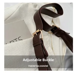 Detail of dark brown leather adjustable shoulder strap with premium golden metal buckle
