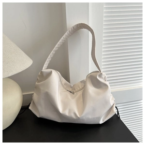 Detail of off-white nylon hobo bag showing pleated texture and wide shoulder strap