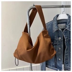 Detailed view of caramel nylon crescent bag with drawstring details on metal hanger