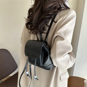 Minimalist black PU leather mini backpack with flap closure and beaded drawstring detail