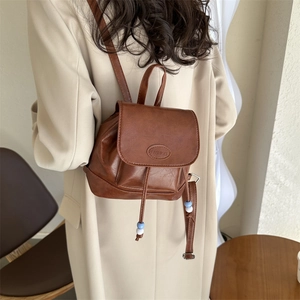 Retro brown mini PU leather backpack with drawstring closure and bead strap details