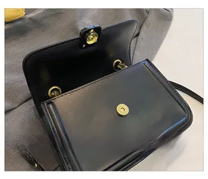 Detailed close-up of the secure magnetic snap closure on a black leather handbag