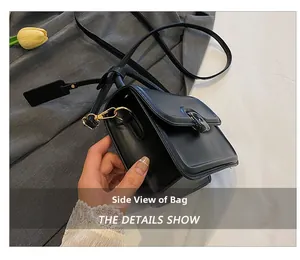 Side view of black leather crossbody square bag showing thickness and gold hardware buckle