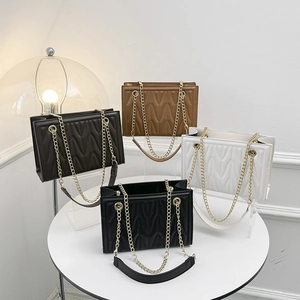 Quilted crossbody chain bags in black, brown, and white with elegant V-stitch leather texture