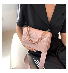 Detail of pink quilted crossbody bag with chunky chain handle and woven strap