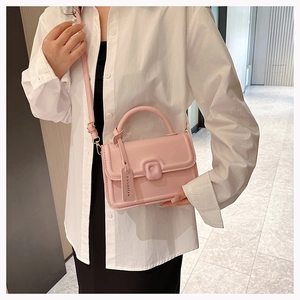 Detail of pink small square crossbody bag with round handle and metal fashion lock