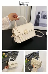 Detail of white rectangle handbag with thick handle and detachable strap on floral background