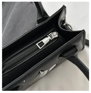 Close-up of smooth black matte leather handbag with durable silver metal zipper closure