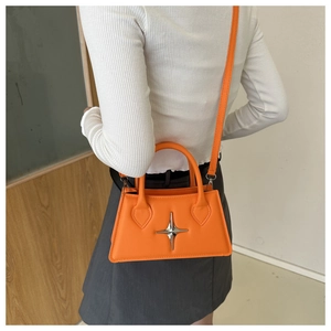 Detailed view of an orange crossbody square bag with a silver star metal buckle