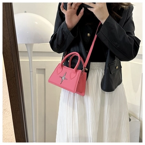 Pink crossbody bag with silver star ornament worn by model in a mirror selfie