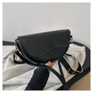 Detail of black saddle bag featuring matte texture and stylish dual shoulder straps