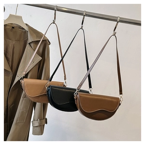 Three minimalist semi-circle saddle bags in khaki black and brown on display