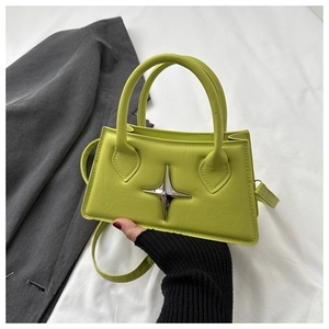 Detail of lime green square handbag with silver star ornament and sleek top handles