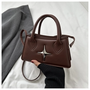 Detail of brown rectangular matte leather handbag with silver star metal hardware