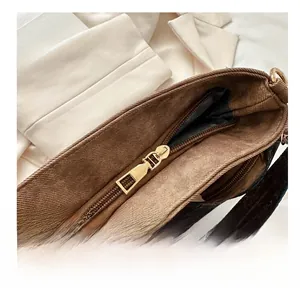 Detail shot of sturdy gold metal zipper closure on brown canvas retro bucket bag