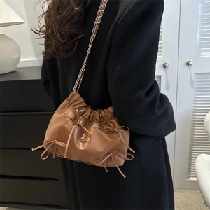 Brown ruched cloud bucket bag with bow accents and silver chain strap for women