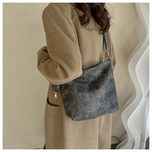 Détail du sac cabas gris vintage avec bandoulière tissée colorée et texture mate
