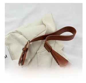 Close-up of durable brown lychee grain leather tote bag strap with fine stitching details